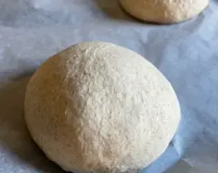 Step <p>SEGUIDAMENTE ECHAR LA MASA SOBRE LA ENCIMERA ENHARINADA, Y ENVOLVER UN POCO LA MASA, YO E SACADO DOS PANES SE PUEDE HACER BARRAS LO QUE MAS OS GUSTE, PONER UN PAPEL DE HORNO SOBRE LA BANDEJA Y DEJAR REPOSAR LOS PANES TAPADOS DE NUEVO ASTA QUE DOBLEN SU VOLUMEN SOBRE MEDIA HORA, SE LE HACEN UNOS CORTES CON UN CUCHILLO AFILADO Y UN POQUITO DE HARINA PARA QUE AL HORNEAR SE TUESTE UN POCO LA CORTEZA.</p> illustration