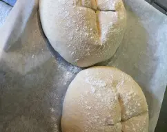 Step <p>PRECALENTAR EL HORNO A 220º CON VENTILACION.</p><p>METER LA BANDEJA CON LOS PANES Y AL SER POSIBLE PODEIS PONER UN RECIPIENTE CON AGUA PARA CREAR HUMEDAD DENTRO, HORNEAR DURANTE 15 MINUTOS A ESTA TEMPERATURA, DESPUES BAJAR LA TEMPERATURA A 190º Y TERMINAR DE HORNEAR OTROS 20 O 25 MINUTOS ASTA QUE AL TOCARLO LA CORTEZA SUENE A HUECO.</p> illustration