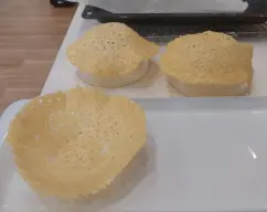 Step <p>Mientras tanto colocamos en una fuente de horno papel de hornear, y hacemos cuatro montones con el queso parmesano rallado, previamente, separados entre sí y hacemos 4 círculos más o menos de unos 14/16 cm de diámetro. </p><p>Los ponemos en el horno entre 8/10 min. hasta que se doren. </p><p>Tendremos un bol, cuenco preparado dado la vuelta. Sacamos del horno el parmesano y con ayuda de una rasera o espátula, pondremos sobre el cuenco y presionamos para darle forma de cesta y poner luego el risotto dentro. </p> illustration